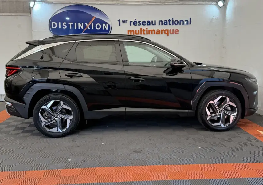 Profil côté gauche du Hyundai Tucson noir 2022 hybride rechargeable, avec jantes modernes et lignes anguleuses marquées.