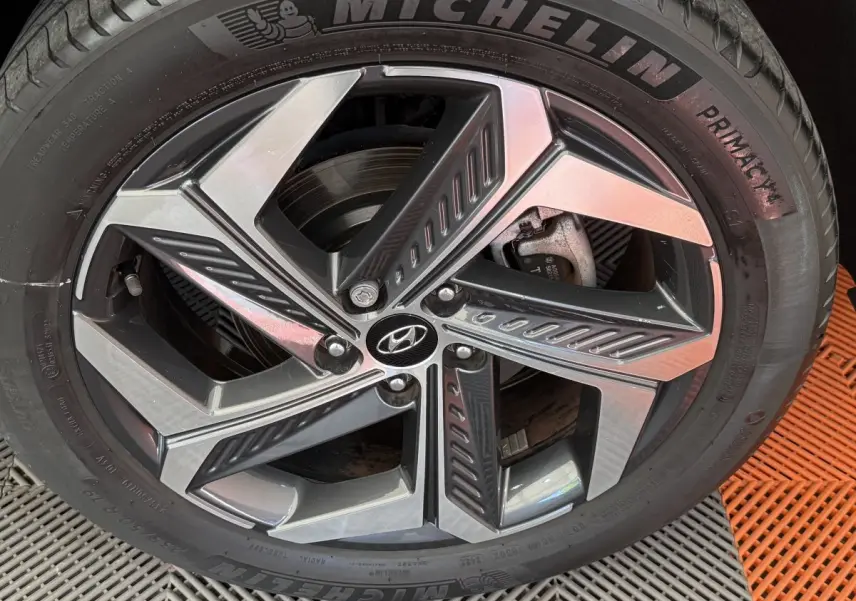 Gros plan sur la roue avant droite du Hyundai Tucson noir 2022 avec jante alliage et pneu Michelin Primacy.