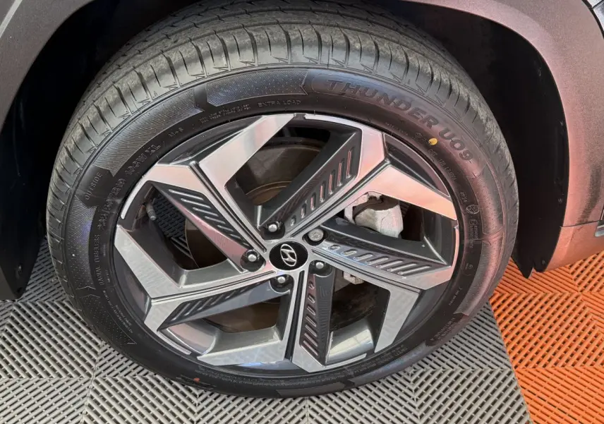 Gros plan sur la roue avant droite du Hyundai Tucson noir, mettant en valeur la jante alliage moderne et le pneu Thunder U09.