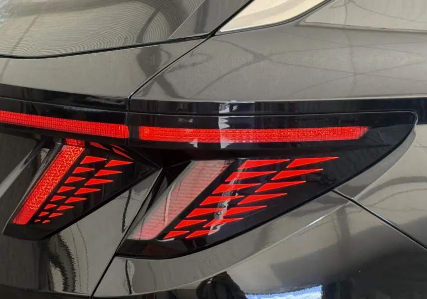 Feu arrière droit allumé du Hyundai Tucson noir 2022, mettant en valeur son design LED anguleux et moderne.