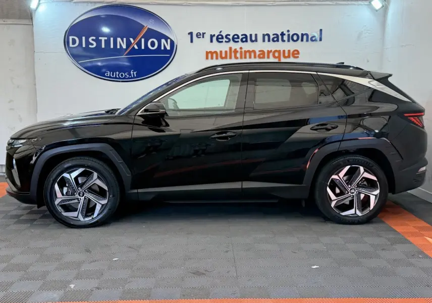 Profil côté gauche d'un Hyundai Tucson noir 2022 avec jantes alliage et toit ouvrant électrique en verre.
