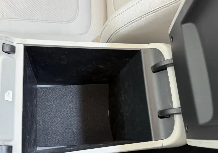 Intérieur du coffre central beige ouvert du Hyundai Tucson 2022, montrant un espace de rangement profond et noir.