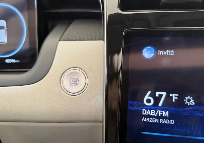 Détail du tableau de bord beige du Hyundai Tucson 2022 avec bouton start/stop et écran tactile affichant la radio.