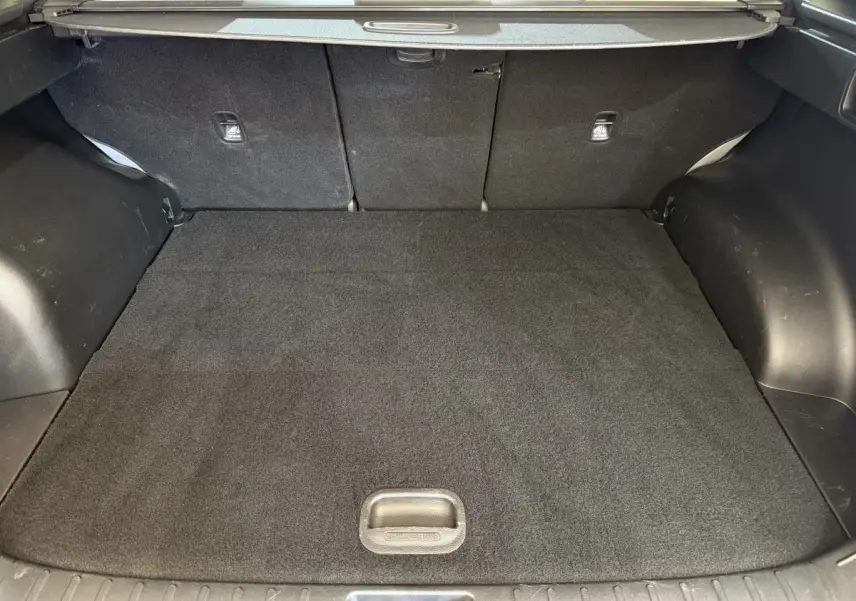 Coffre noir du Hyundai Tucson 2022 vu de face, avec tablette cache-bagages et tapis de sol propre.