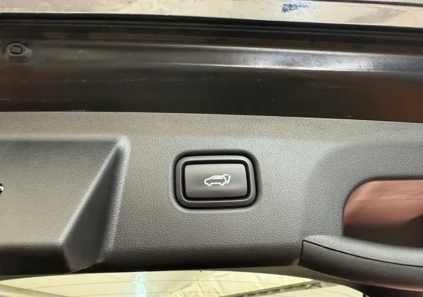 Bouton d'ouverture électrique du coffre sur la garniture intérieure du hayon d'un Hyundai Tucson noir 2022.
