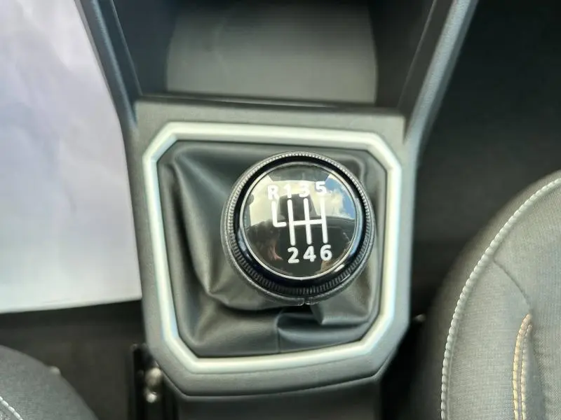 Gros plan sur le levier de vitesses manuel noir du Dacia Sandero Stepway 2025 en Gris Schiste métallisé, intérieur visible.