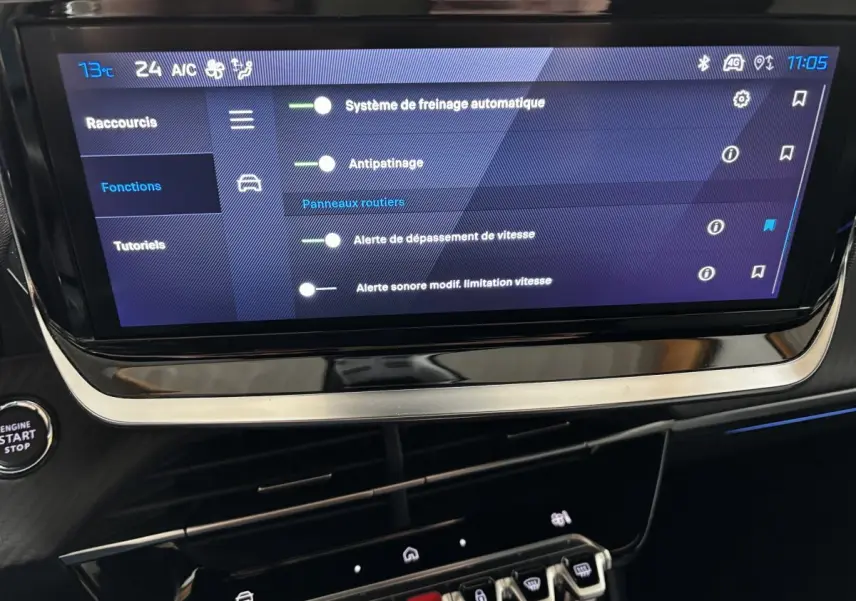Écran tactile central affichant les réglages d’aide à la conduite dans l’habitacle d’une Peugeot 208 Hybrid gris clair.