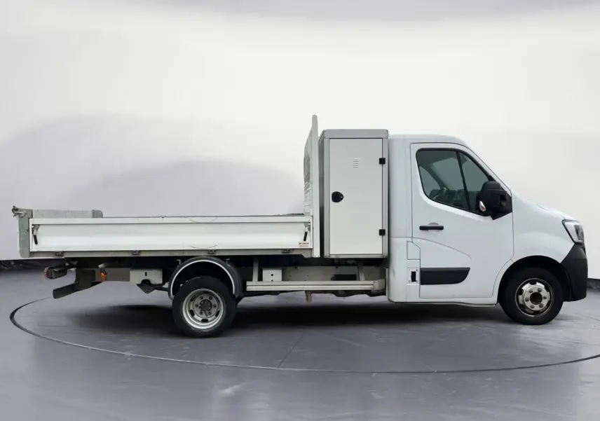 Profil droit d’un Renault Master Châssis Cabine blanc 2023 avec benne, coffre latéral et roues jumelées arrière.