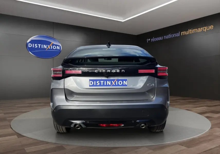 Vue arrière d'une Citroën C4 hybride gris foncé, avec feux arrière LED et double sortie d'échappement visibles.