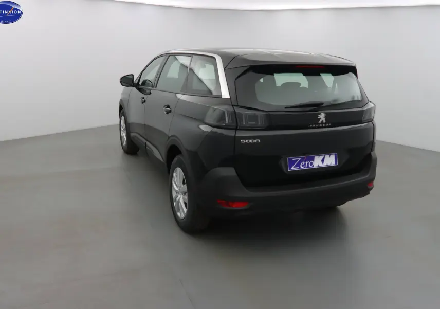 Peugeot 5008 noir perle métal vue 3/4 arrière gauche dans un studio lumineux avec logo Distinxion visible.