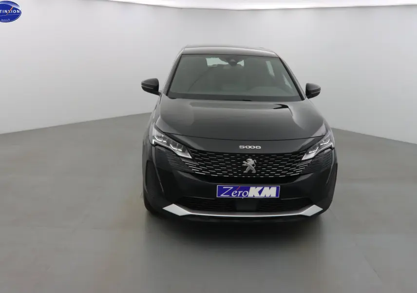 Peugeot 5008 noir perle métal vue de face dans un studio, mettant en valeur sa calandre distinctive et ses phares LED.