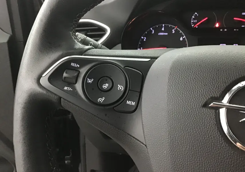 Gros plan sur le volant noir de l’Opel Crossland 2022, montrant les commandes de régulateur de vitesse à gauche.