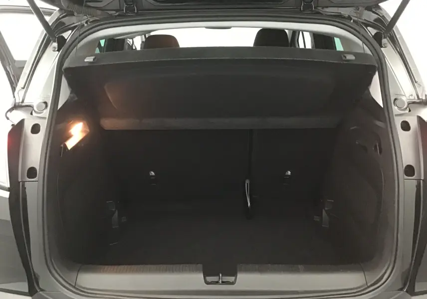 Coffre ouvert vu de l'arrière d'un Opel Crossland noir 2022, montrant un espace de chargement vide et éclairé.