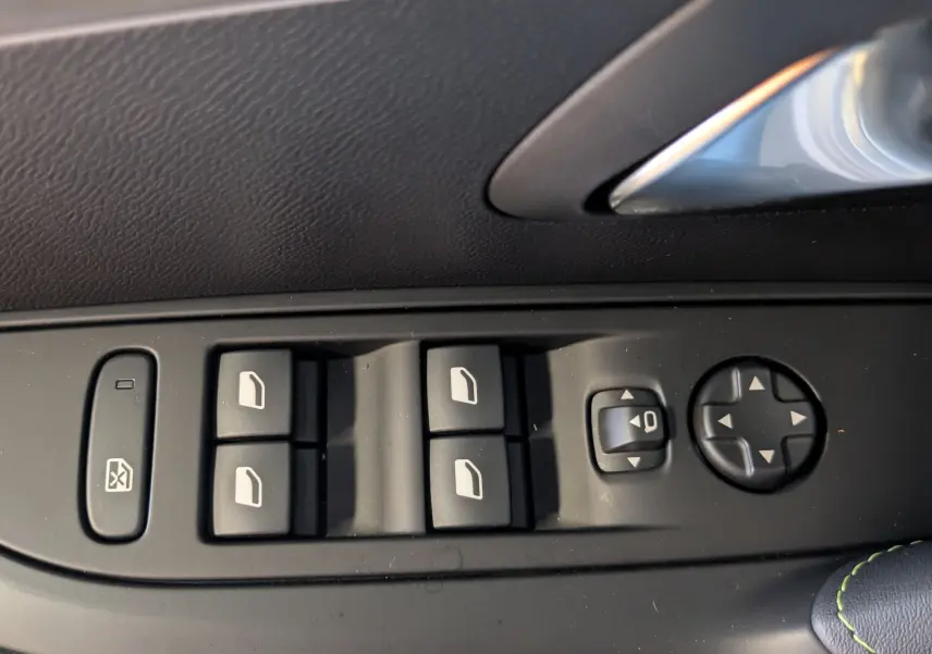 Panneau de commandes des vitres et rétroviseurs côté gauche intérieur d'une Peugeot 208 Hybrid 145 Gris Artens 2024.