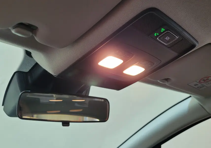 Plafonnier intérieur allumé avec bouton SOS et rétroviseur central dans une Renault Clio bleu 2025.