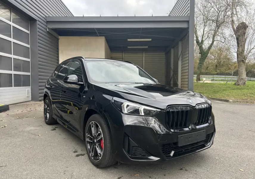 BMW X1 XDRIVE 20D M SPORT 2025 noir Black Saphire en 3/4 avant avec jantes sport et étriers rouges visibles
