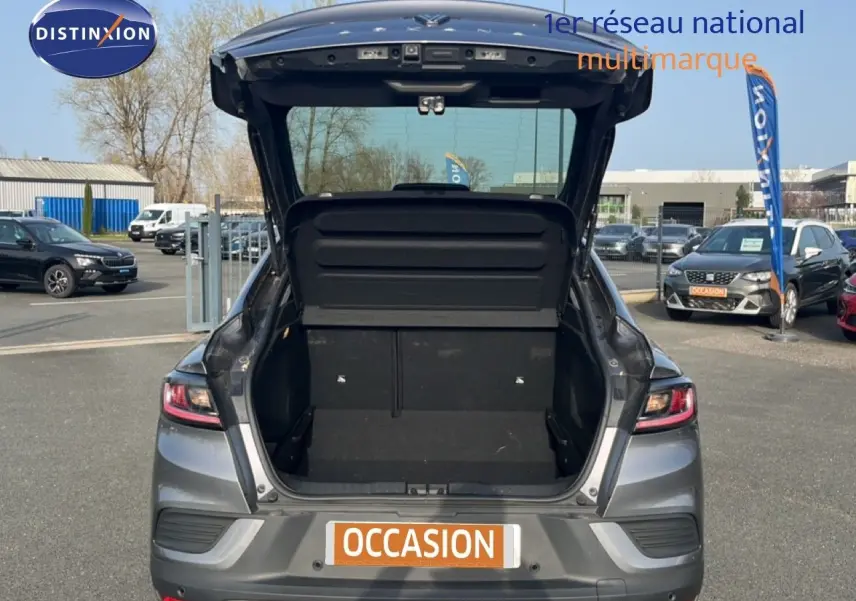 Vue arrière avec coffre ouvert d'une Renault Arkana gris satin métal 2025 sur parking extérieur.