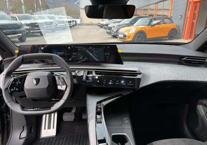 Vue intérieure frontale du Peugeot 3008 Hybrid 145 GT Alcantara avec tableau de bord numérique et volant cuir multifonctions.