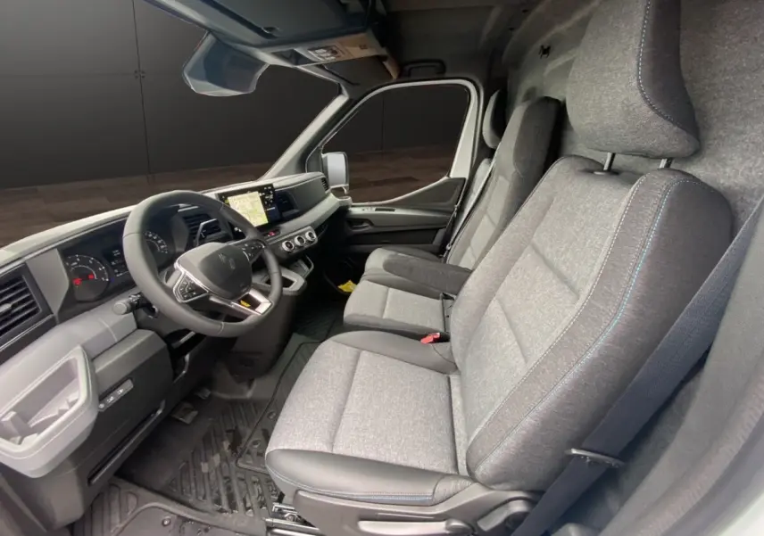 Vue intérieure côté conducteur du Renault Master 2026, montrant les sièges gris et le tableau de bord avec écran tactile.