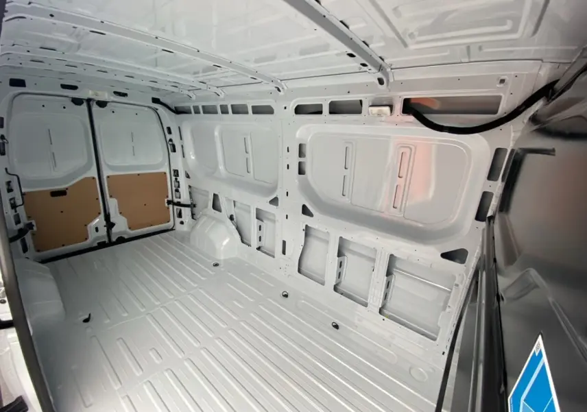 Vue intérieure arrière du Renault Master blanc, montrant l'espace de chargement vide et la cloison pleine.