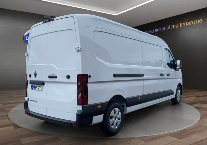 Renault Master blanc en vue 3/4 arrière droit, fourgon utilitaire avec feux arrière LED et bandes latérales noires.