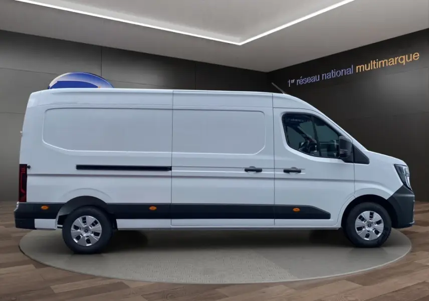 Vue de profil côté droit d’un Renault Master blanc, fourgon utilitaire avec bande noire basse et jantes argentées.