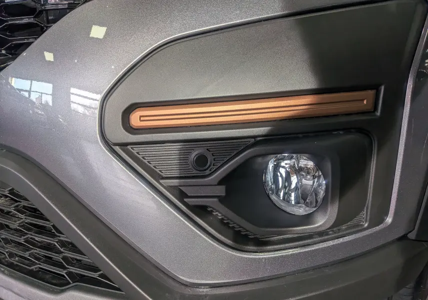 Gros plan sur le feu antibrouillard droit de la Dacia Sandero Stepway 2025 gris schiste avec insert décoratif cuivre.