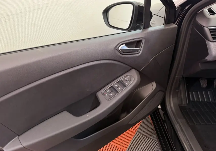 Intérieur côté gauche de la porte avant noire de la Renault Clio 2025 avec commandes de vitres et rétroviseur.
