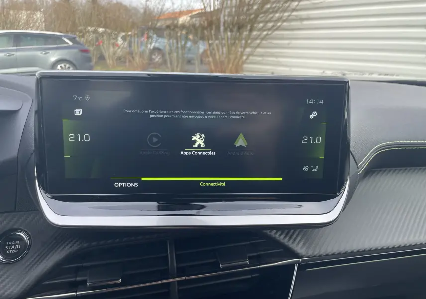 Écran tactile central du tableau de bord du Peugeot 2008 gris Artense, affichant les options de connectivité et la climatisation à 21°C.