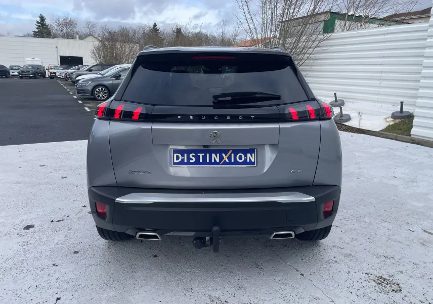 Vue arrière d’un Peugeot 2008 gris Artense 2022 avec feux LED distinctifs et double sortie d’échappement chromée.