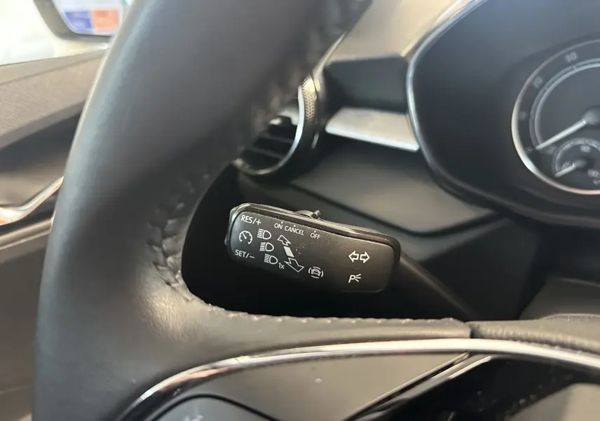 Gros plan sur la commande de régulateur de vitesse derrière le volant d'une Skoda Fabia Ambition gris argent 2023.