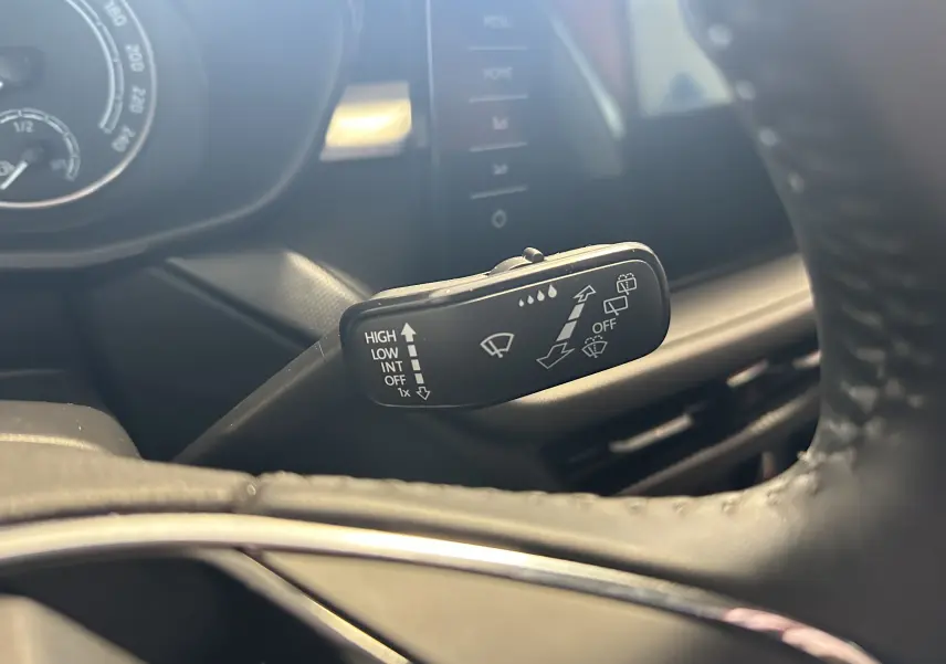 Gros plan sur la manette d’essuie-glace à gauche du volant dans l’habitacle d’une Skoda Fabia gris argent 2023.