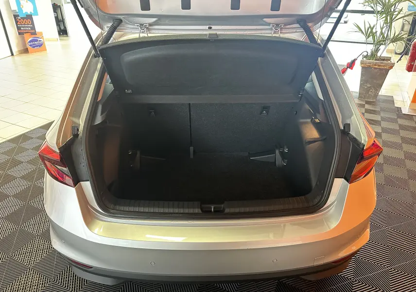 Vue arrière du coffre ouvert d'une Skoda Fabia Ambition gris argent 2023, montrant l'espace de chargement vide.