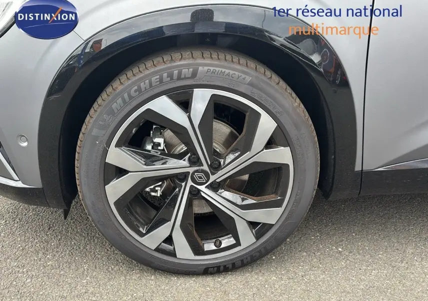 Gros plan sur la roue avant gauche d'un Renault Austral gris schiste satin mat avec jante alliage au design moderne.