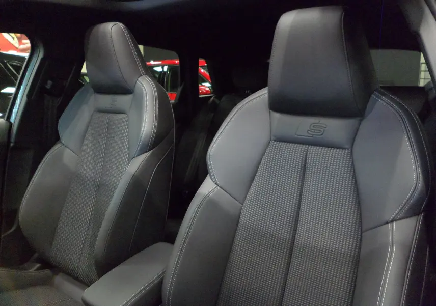 Gros plan sur les sièges avant en cuir noir avec surpiqûres blanches et logo S de l'Audi A3 Sportback 2025.