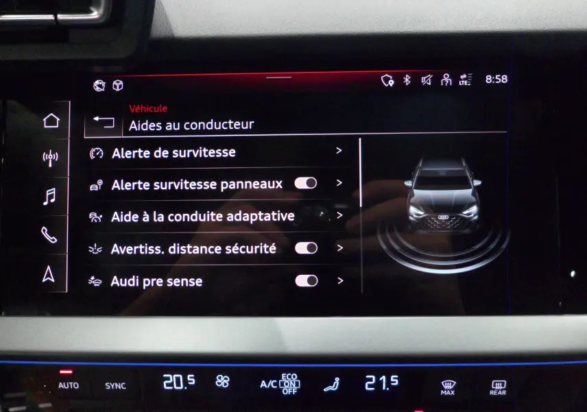 Écran tactile intérieur affichant les aides à la conduite de l'Audi A3 Sportback 35 TFSI gris Daytona, vue frontale virtuelle.