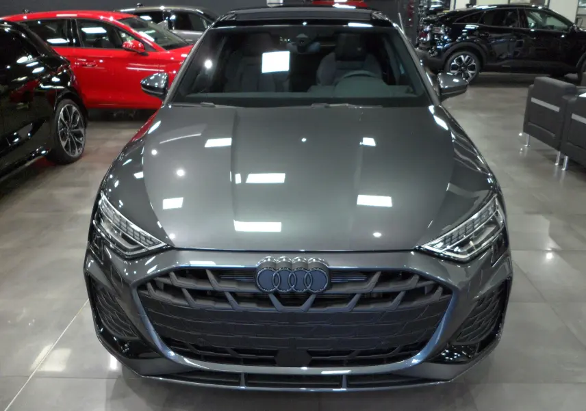 Vue frontale d'une Audi A3 Sportback 35 TFSI S-Line gris Daytona avec calandre noire et phares LED marqués.