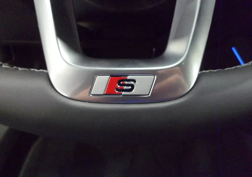 Gros plan sur le volant en cuir noir avec logo S soulignant la finition S-Line de l'Audi A3 Sportback 2025.