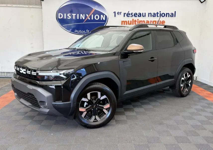 Dacia Duster 2025 noir en 3/4 avant droit, avec jantes bicolores et rétroviseurs couleur cuivre.