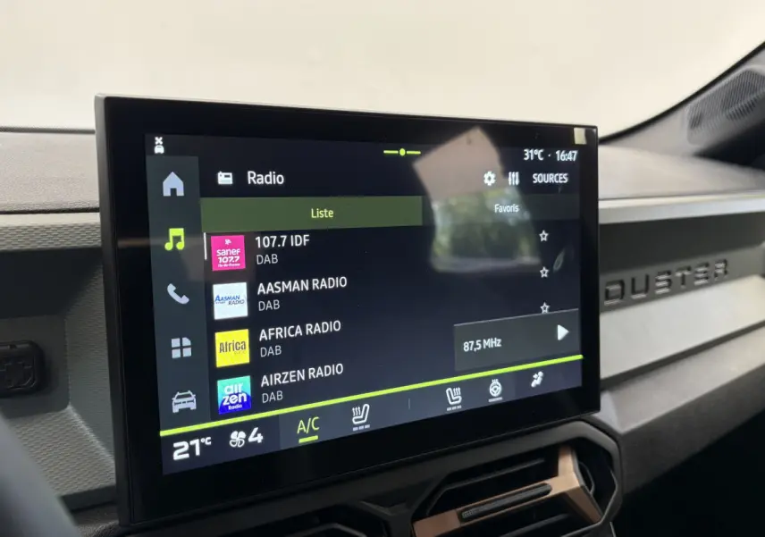 Écran tactile central du tableau de bord du Dacia Duster noir, affichant les stations radio numériques.