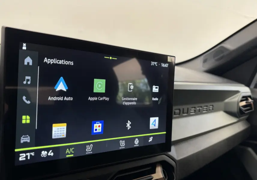 Écran tactile central affichant Apple CarPlay dans l'habitacle du Dacia Duster noir, version 2025.