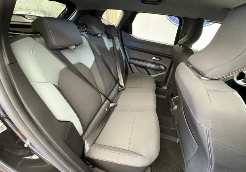 Vue intérieure côté gauche des sièges arrière gris clair et noir du Dacia Duster 2025 hybride mild hybrid.