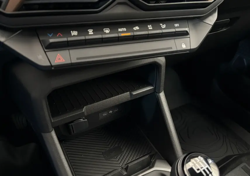 Gros plan sur la console centrale du Dacia Duster noir 2025, avec commandes climatisation et boîte manuelle visible
