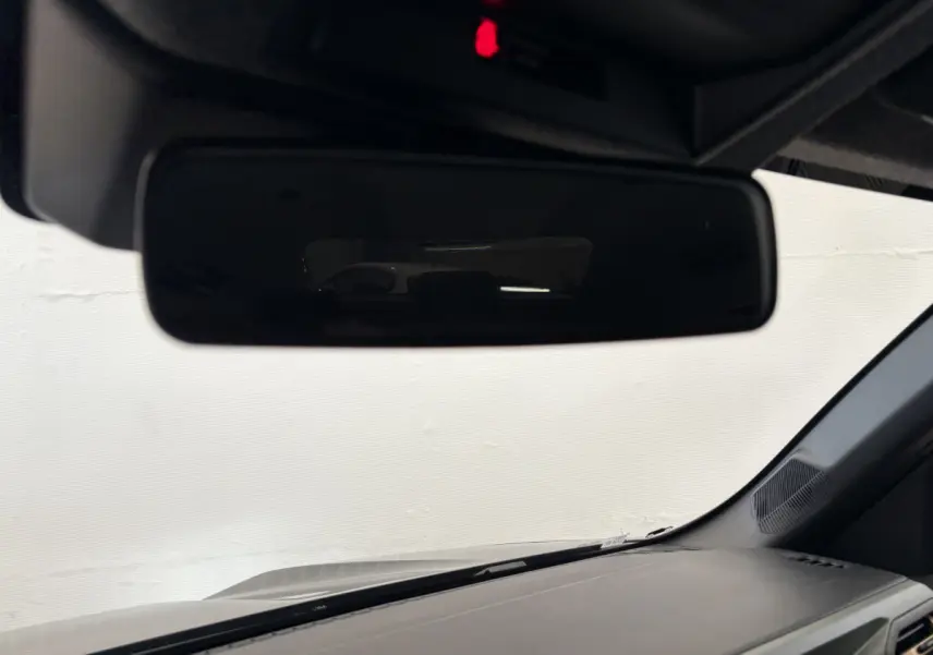 Vue intérieure du rétroviseur central du Dacia Duster noir 2025, avec tableau de bord et pare-brise visibles.