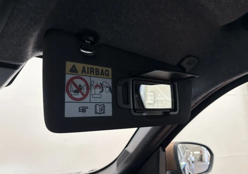 Miroir de courtoisie ouvert sur le pare-soleil côté conducteur du Dacia Duster noir, intérieur vue rapprochée.