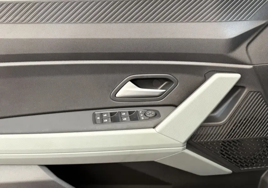 Gros plan sur la porte côté gauche du Dacia Duster noir 2025, avec commandes de vitres et poignée argentée.