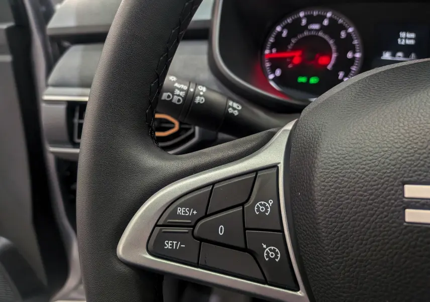 Gros plan sur le volant noir de la Dacia Sandero Stepway 2025, avec commandes de régulateur de vitesse visibles.