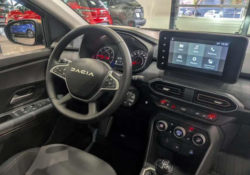 Vue intérieure côté conducteur du Dacia Sandero Stepway TCe 110 Gris Schiste, avec tableau de bord et écran tactile visible.