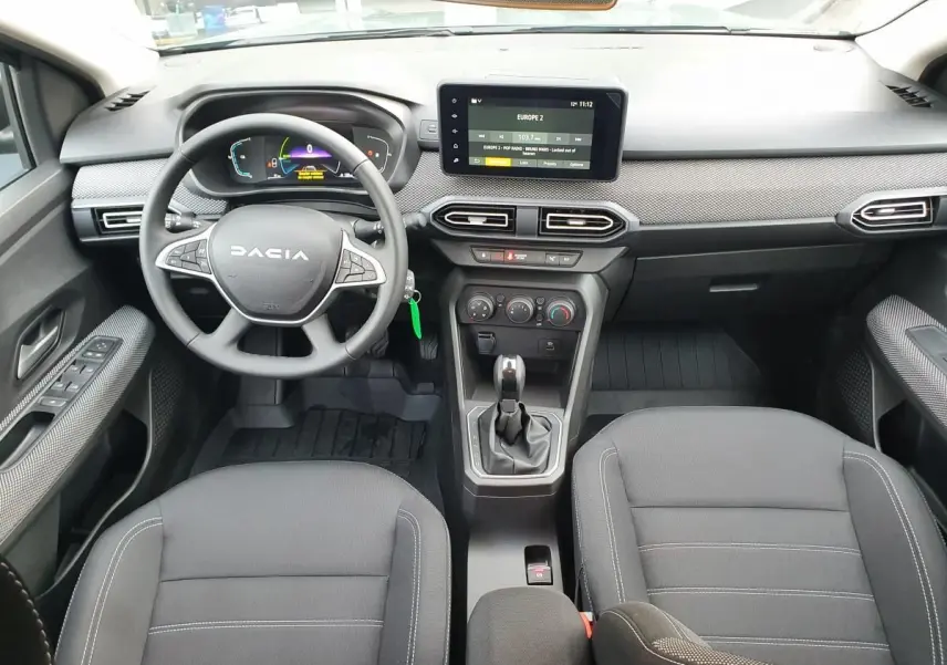 Vue intérieure frontale du tableau de bord et volant du Dacia Jogger 2024, avec écran tactile et sellerie noire.