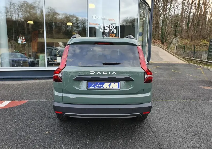 Vue arrière d'un Dacia Jogger 2024 vert Licken Kaki avec feux verticaux et barres de toit visibles.